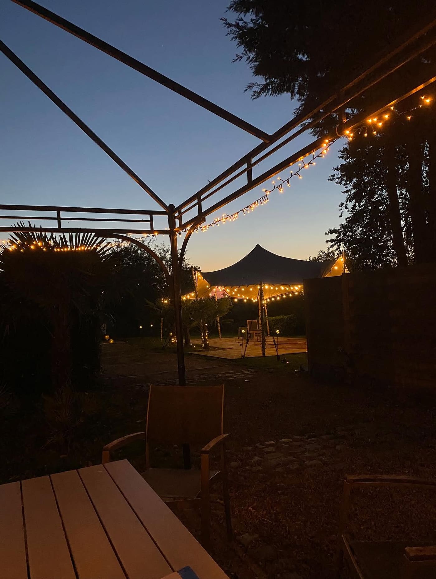 Verlichte tent in de tuin van Artivent bij valavond